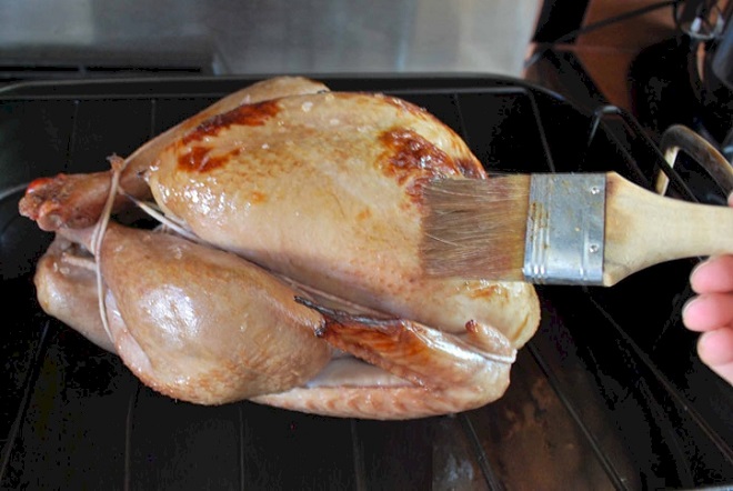 Dùng cọ hoặc tay phết đều nước sốt lên gà trước và trong khi nướng
