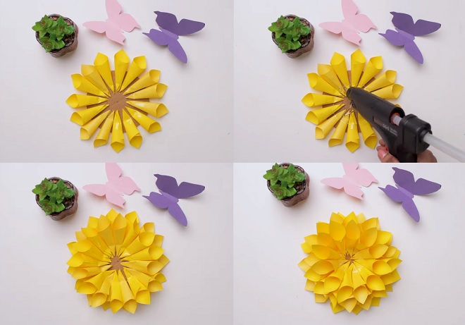dán các mẫu giấy hình nón vào đế bìa carton tạo thành các lớp hoa hướng dương