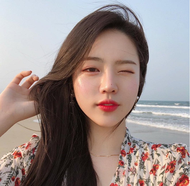 Koreanisches Mädchen, das Fotos auf dem Strand macht