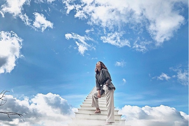 cô gái áo xám đứng chụp ảnh trên nấc thang lên thiên đường