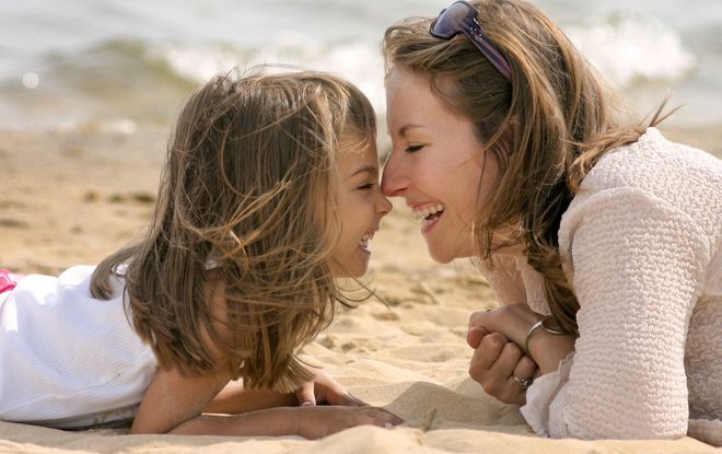 mẹ và con gái âu yếm nhau trên bãi biển