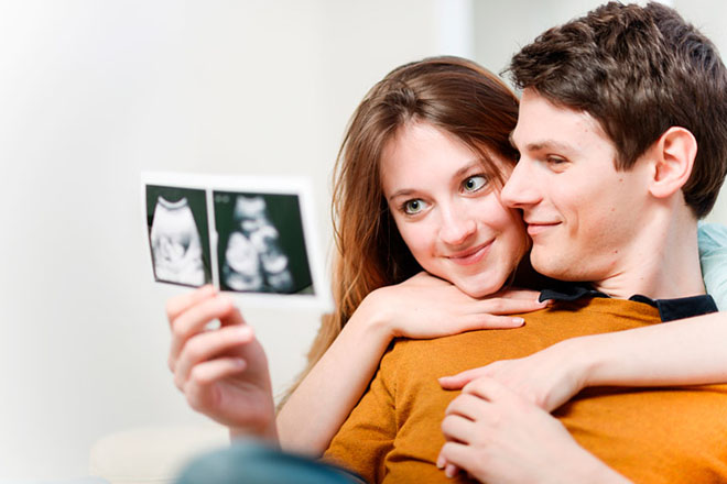 Vợ chồng hạnh phúc xem kết quả siêu âm thai