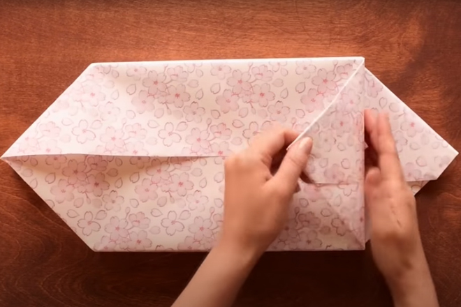 Gấp các góc của tờ giấy vào cạnh của hộp quà